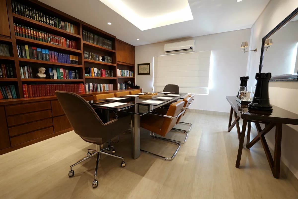 Sala de reunião com mesa longa e cadeiras estofadas
